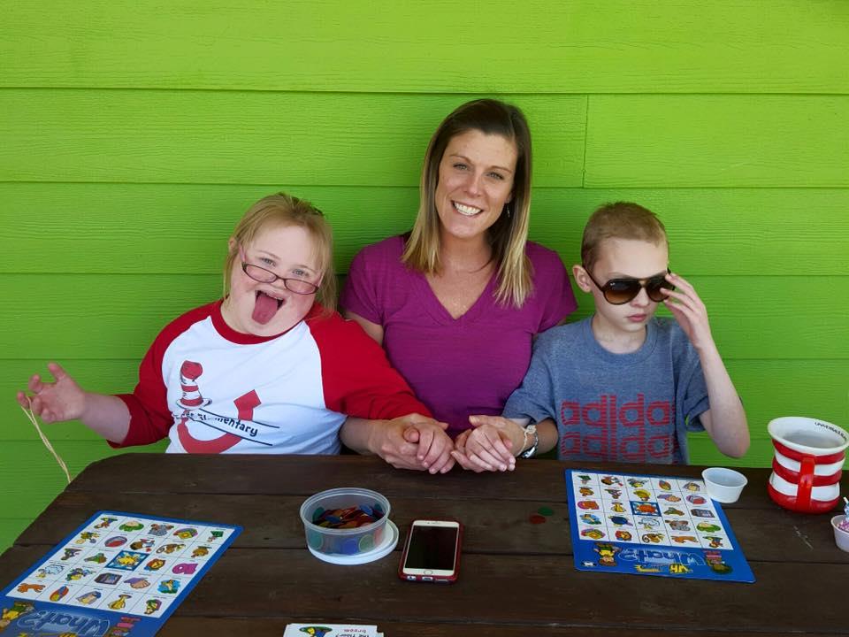 A woman and two boys sitting at a table.
