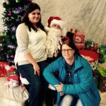 Two women and a man in santa costume