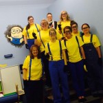 A group of people in yellow shirts and blue pants.