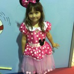 A little girl in minnie mouse costume posing for the camera.