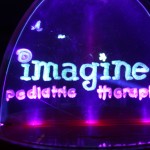 A neon sign that says imagine pediatric therapy.