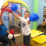 A boy is playing with balloons in the room