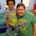 A woman and boy in matching shirts pose for the camera.