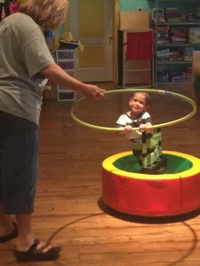 A child is playing with a hula hoop.