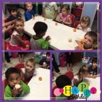 A group of kids sitting at a table eating cupcakes.