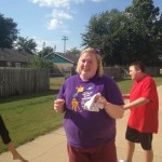 A woman in purple shirt holding onto something
